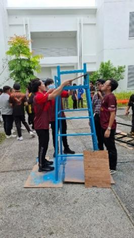 A group of people standing next to a blue ladder

Description automatically generated
