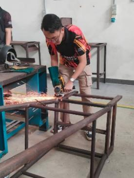 A person using a grinder to cut a metal piece
